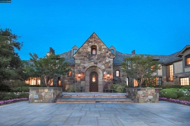 english style home featuring a patio area