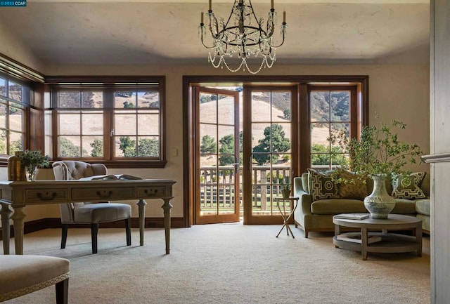 sitting room featuring a notable chandelier, plenty of natural light, and light colored carpet