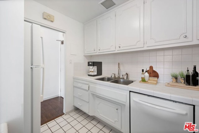 kitchen featuring sink, white cabinetry, light tile floors, and dishwasher