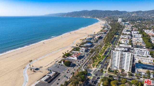 aerial view featuring a view of the beach and a water and mountain view