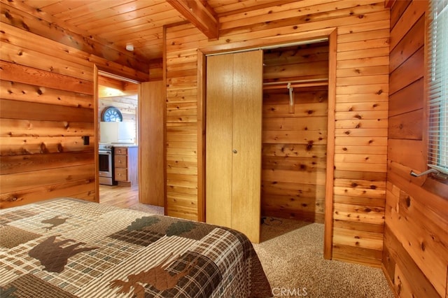 carpeted bedroom featuring beam ceiling, a closet, wooden ceiling, and wood walls