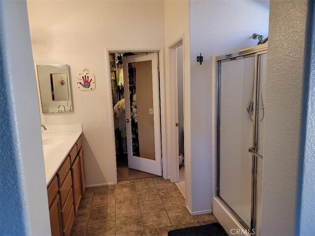 bathroom with a shower with door and vanity