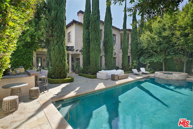 view of pool with area for grilling, a patio area, and an in ground hot tub