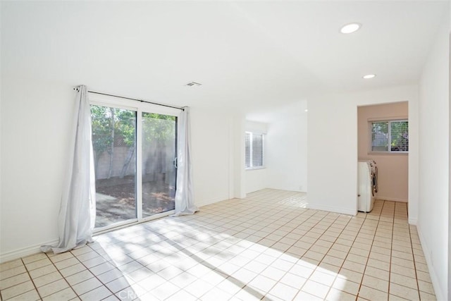 tiled empty room featuring washing machine and dryer