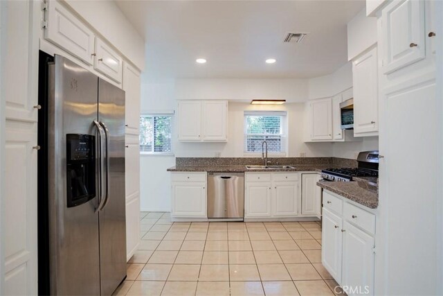 kitchen with a healthy amount of sunlight, white cabinetry, sink, and stainless steel appliances