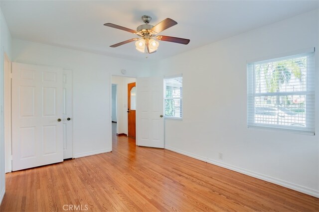 unfurnished bedroom with a closet, light hardwood / wood-style flooring, and ceiling fan