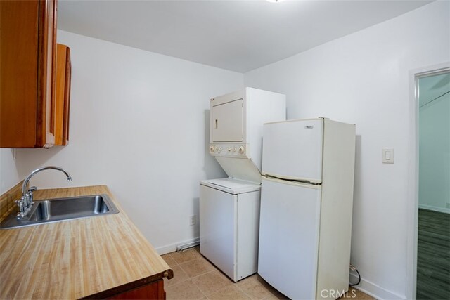 washroom with sink and stacked washer and clothes dryer