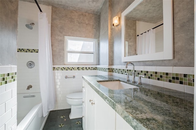 full bathroom featuring tile patterned floors, toilet, shower / bath combo with shower curtain, vanity, and tile walls