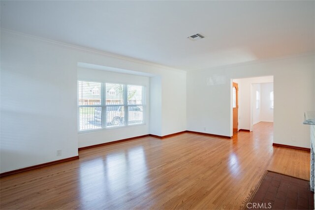 unfurnished room featuring crown molding and light hardwood / wood-style floors