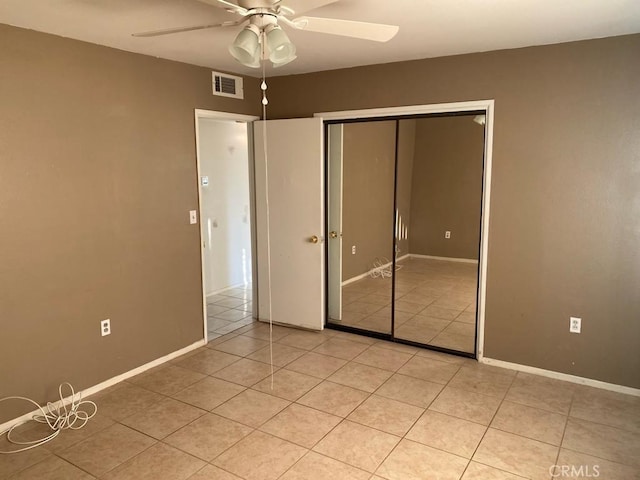 unfurnished bedroom with ceiling fan, light tile patterned floors, and a closet