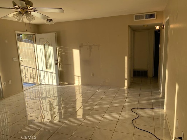 tiled spare room with ceiling fan