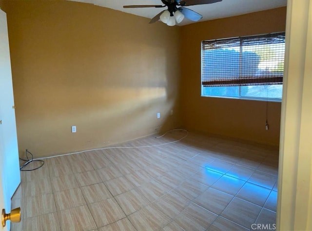 empty room with ceiling fan and light tile patterned floors