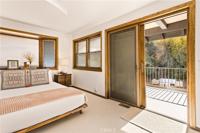 carpeted bedroom with multiple windows, ceiling fan, and access to exterior