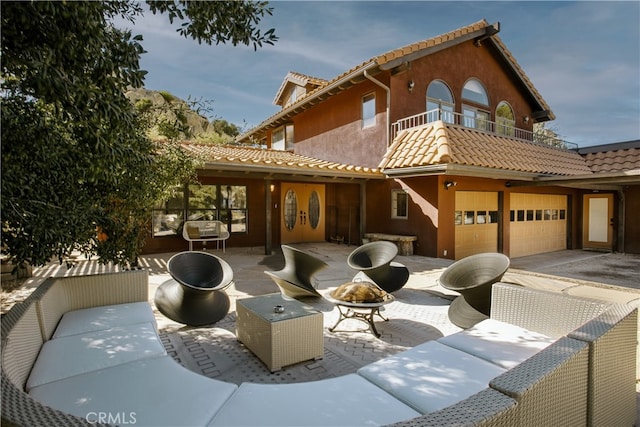 view of front of home with a balcony, a garage, and a patio