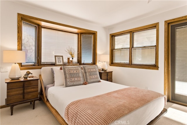 bedroom featuring light carpet and multiple windows