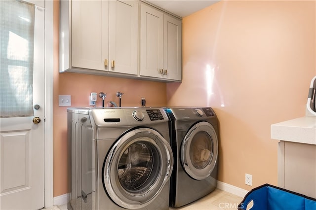 laundry room featuring cabinets and washing machine and clothes dryer