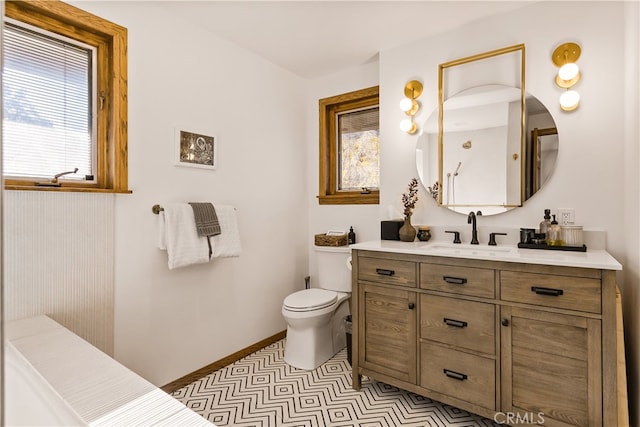 bathroom with vanity, toilet, and a wealth of natural light