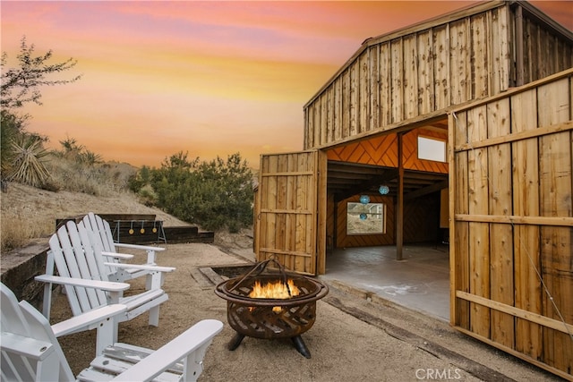 patio terrace at dusk featuring a fire pit