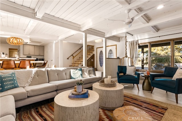 tiled living room featuring ceiling fan with notable chandelier, beamed ceiling, and wooden ceiling