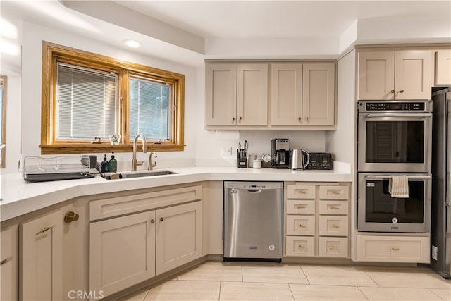 kitchen with light tile patterned flooring, stainless steel appliances, and sink