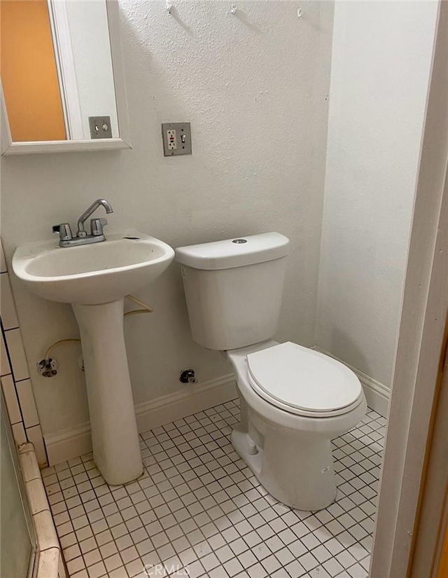 bathroom featuring toilet and tile patterned flooring