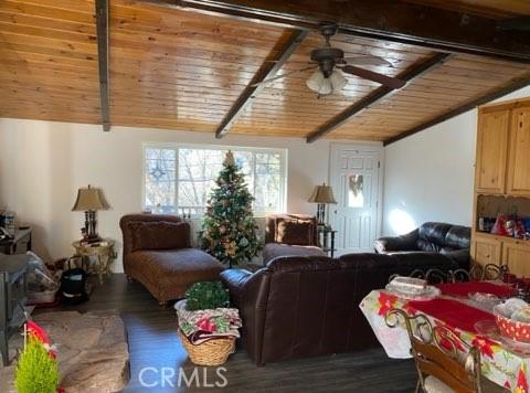 living room featuring ceiling fan, dark hardwood / wood-style flooring, and wood ceiling