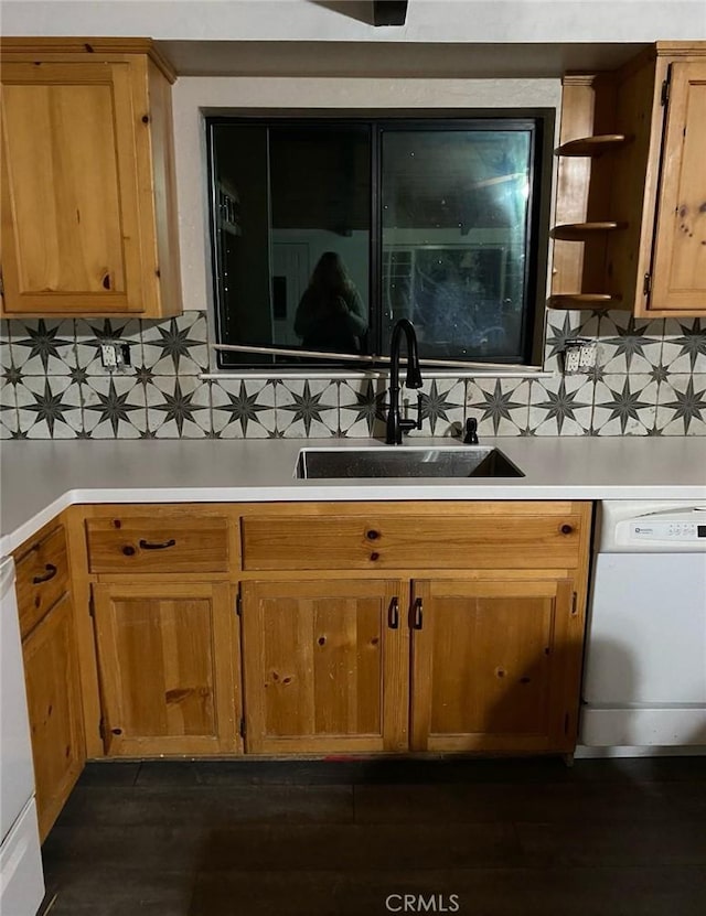 kitchen with backsplash, dark hardwood / wood-style flooring, sink, and white dishwasher