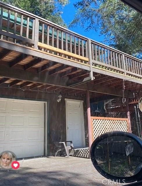 rear view of house featuring a garage and a balcony