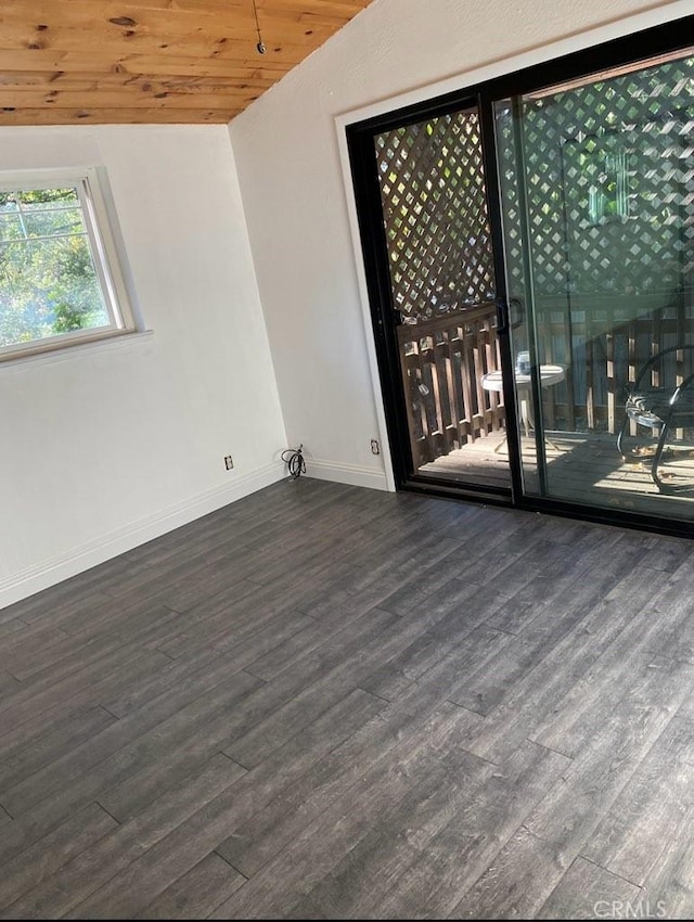 empty room with lofted ceiling, dark wood-type flooring, and wood ceiling