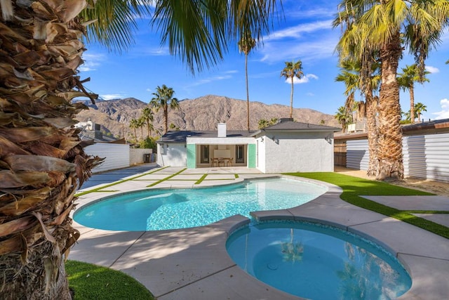 view of pool featuring a mountain view and an in ground hot tub