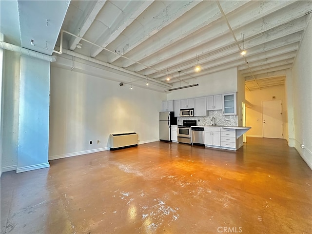 unfurnished living room featuring sink and concrete flooring