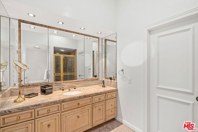 bathroom featuring vanity, hardwood / wood-style floors, and a shower with door