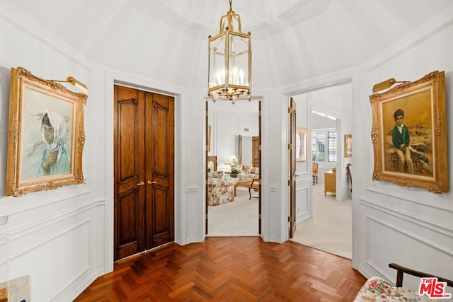 entrance foyer featuring an inviting chandelier and dark parquet floors