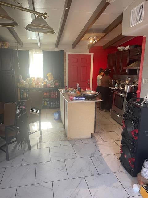 kitchen with beam ceiling, exhaust hood, and electric stove