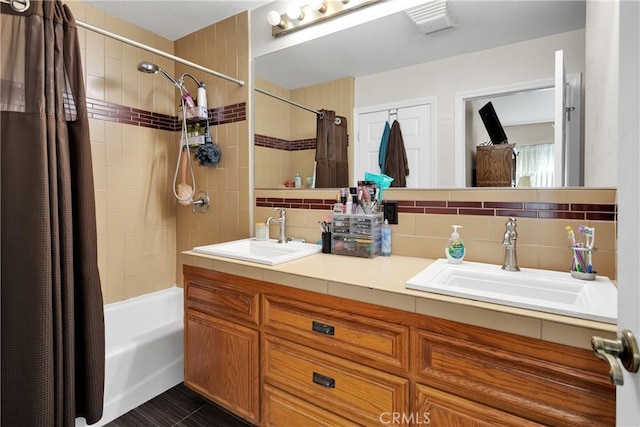 bathroom with vanity, tile patterned floors, shower / bath combination with curtain, decorative backsplash, and tile walls