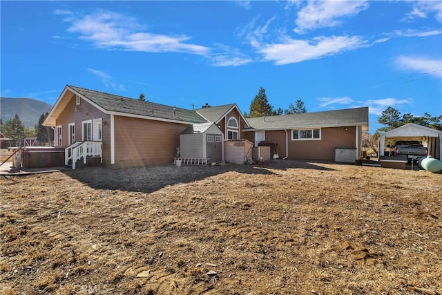 rear view of house with a mountain view and a hot tub