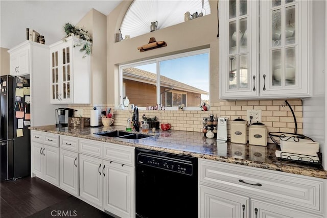 kitchen featuring sink, white cabinetry, dark stone counters, and black appliances