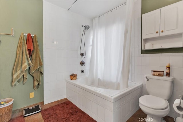 bathroom with tile patterned floors, toilet, shower / bathtub combination with curtain, and tile walls