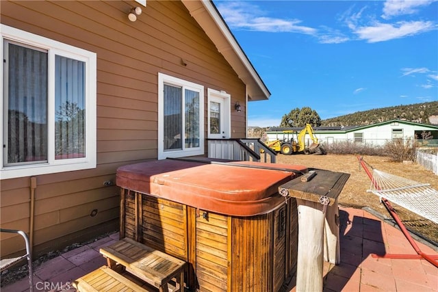 wooden deck with a hot tub and a patio area