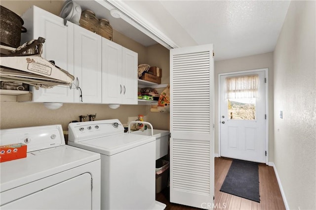 washroom featuring separate washer and dryer, dark wood-type flooring, cabinets, and sink