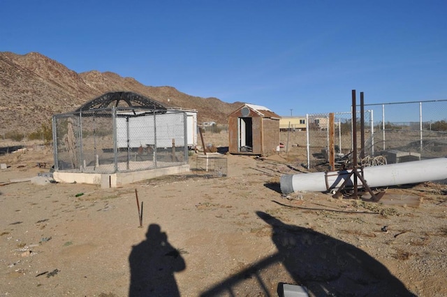 view of yard featuring a mountain view and a storage shed