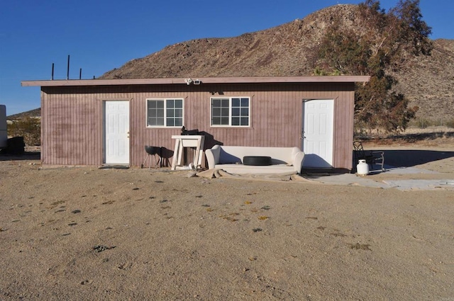 back of house featuring a lawn and a mountain view