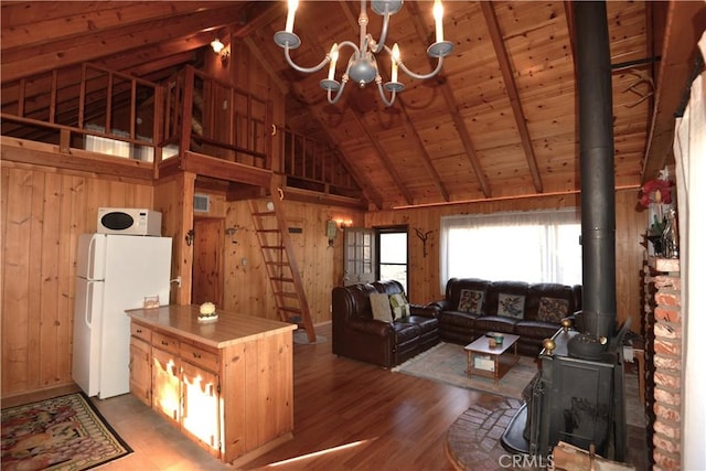 unfurnished living room with wood ceiling, a wood stove, dark wood-type flooring, and wooden walls