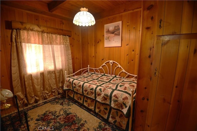 bedroom featuring wood walls, beamed ceiling, and wooden ceiling