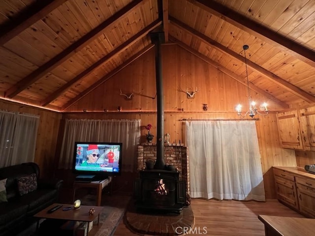 living room with a wood stove, light hardwood / wood-style flooring, wooden ceiling, and beam ceiling