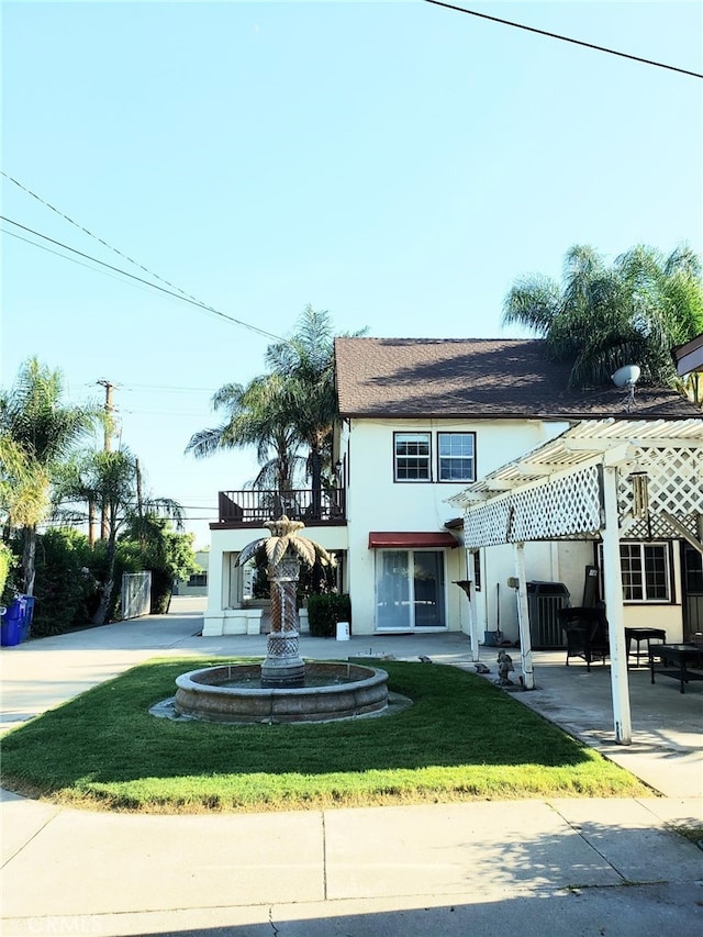 view of front of property featuring a front lawn and a balcony