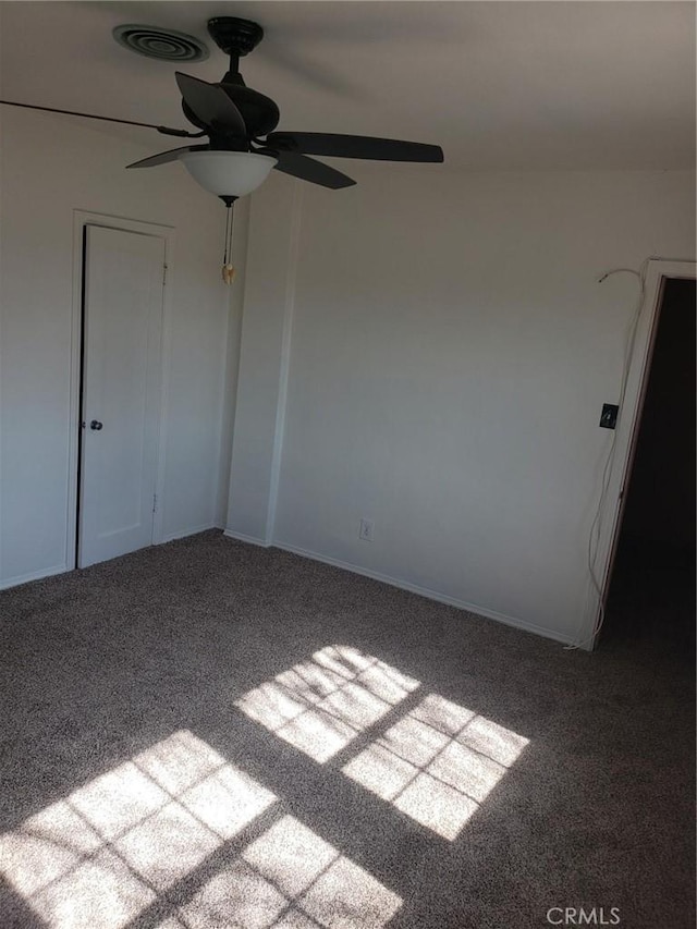 carpeted spare room featuring ceiling fan