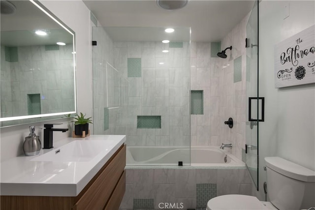 full bathroom with combined bath / shower with glass door, vanity, and toilet