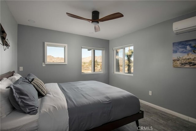 bedroom with ceiling fan, dark wood-type flooring, multiple windows, and a wall mounted air conditioner