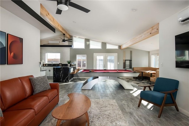 rec room with an AC wall unit, wood-type flooring, french doors, lofted ceiling with beams, and ceiling fan